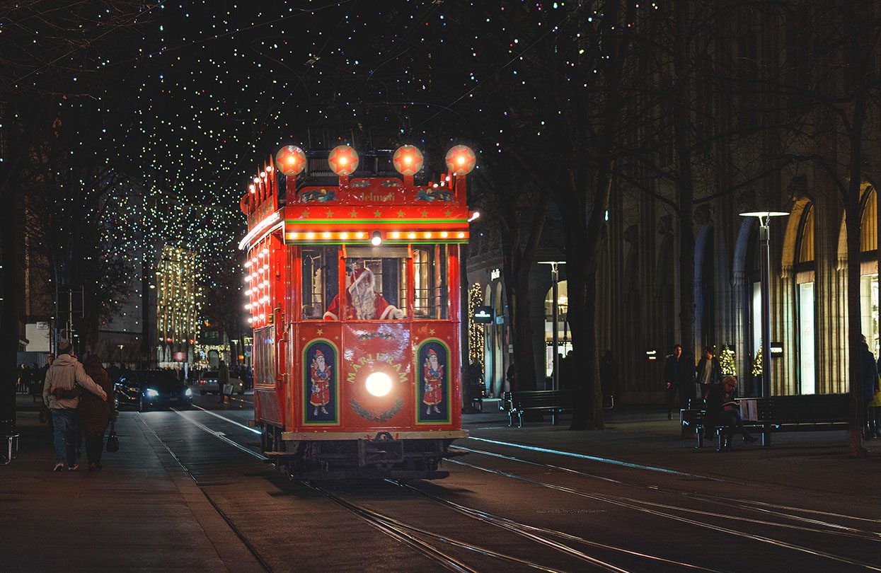 Santa driving through Zurich on his brightly decorated red Märlitram, image by Mario Modena, Zürich Tourism